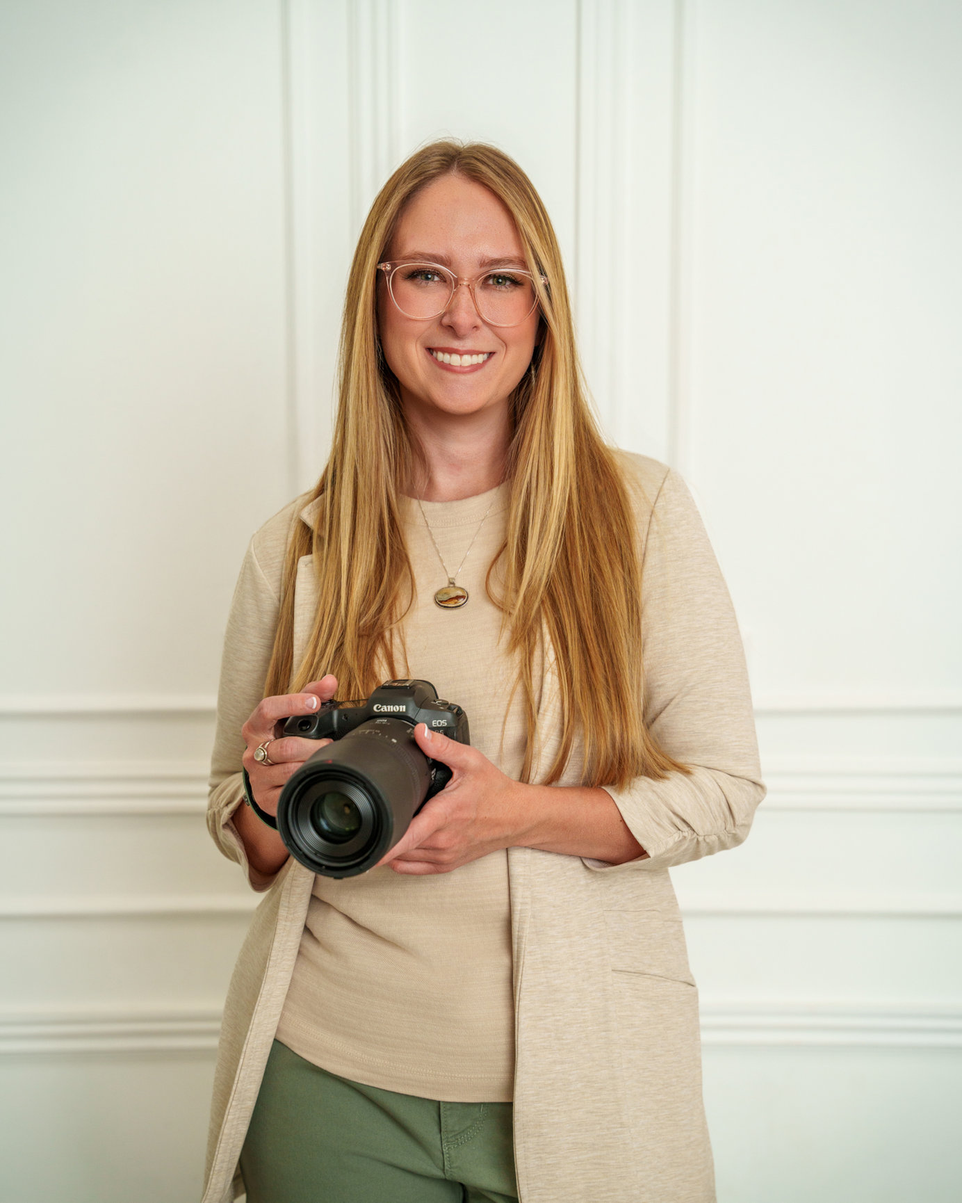 Ellie Hansen, portrait photographer and bookkeeper, holding a camera
